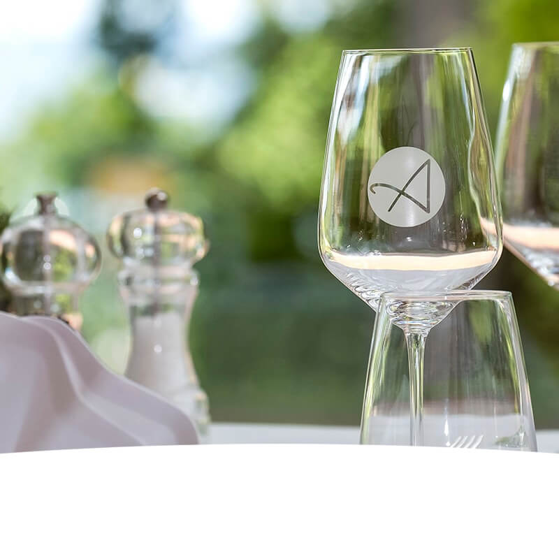 Gedeckter Tisch mit Weingläser auf denen das Anders am Meer Logo drauf gedruckt ist