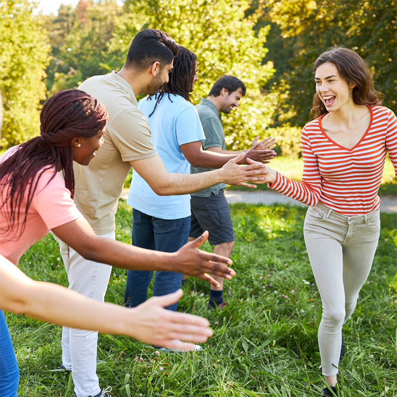 Teambuilding Incentives Gruppe von Personen im Grünen, die sich abklatschen